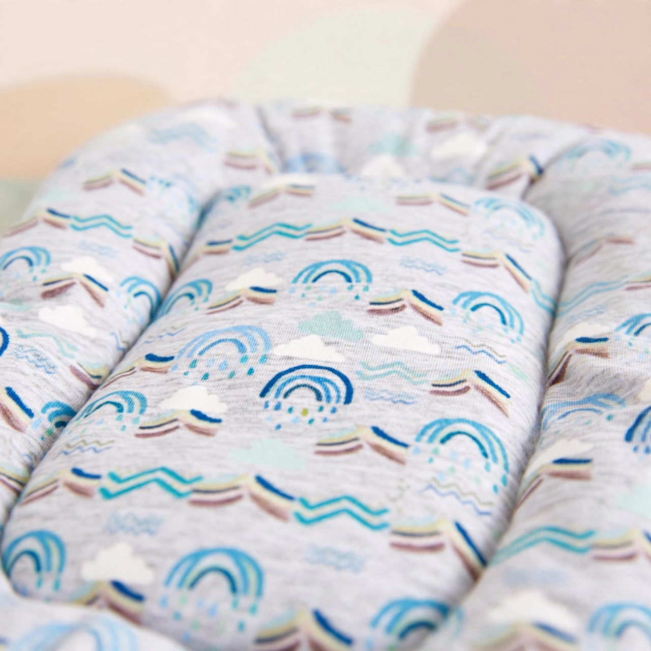 Close-up of the blue rainbow cloud print cushion