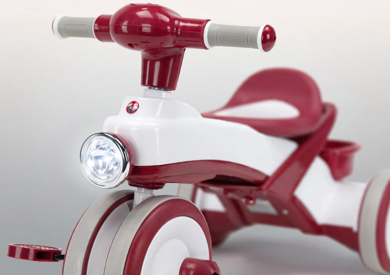 Red plastic tricycle headlight close-up, studio shot